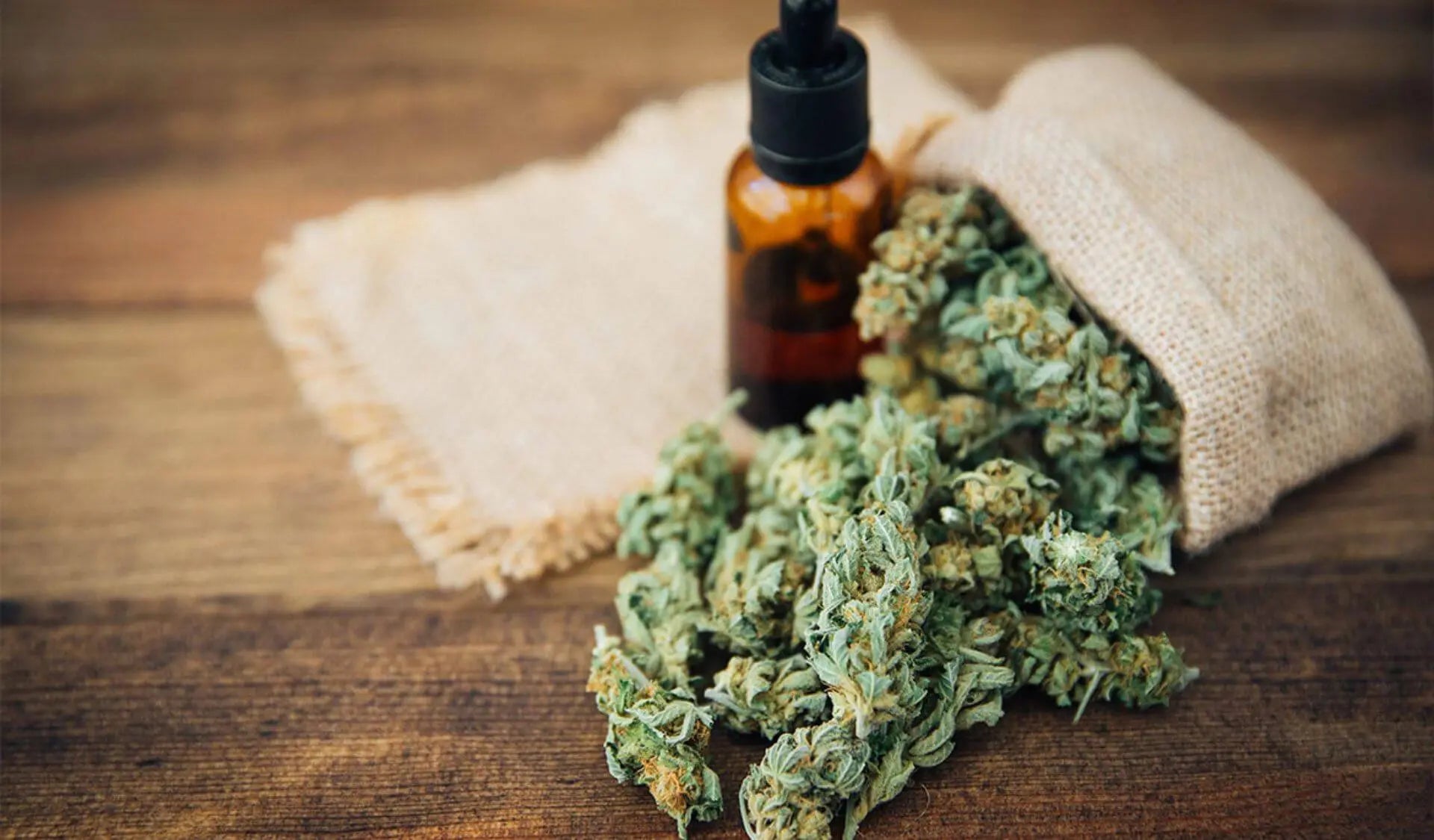 CBD Blüten mit Hanföl auf Holztisch