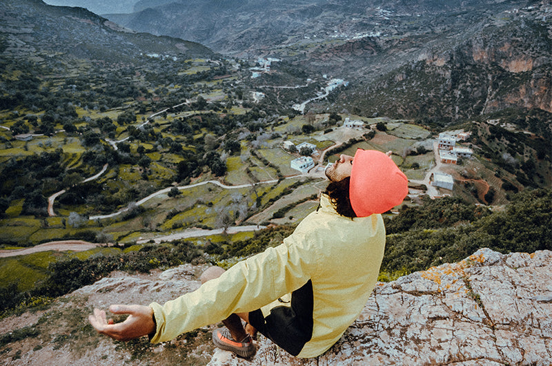 Atemberaubende Aussicht ins Tal eines Bergsteiger der seine Hände streckt und die Freiheit genießt 