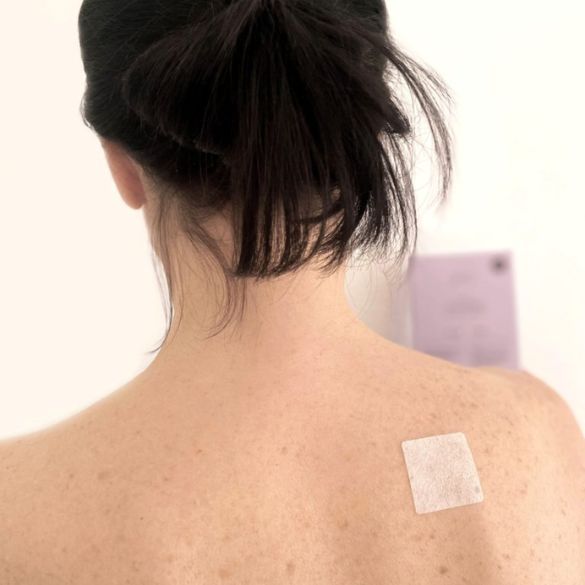 BioBloom Schmerzpflaster Anwendung inszeniert am Rücken einer Frau