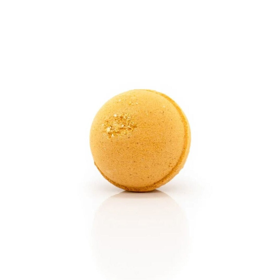Goldene CBD-Badebombe mit schimmernden Glitzer-Akzenten auf weißem Hintergrund, luxuriöses Wellness-Produkt für entspannende Badeerfahrungen
