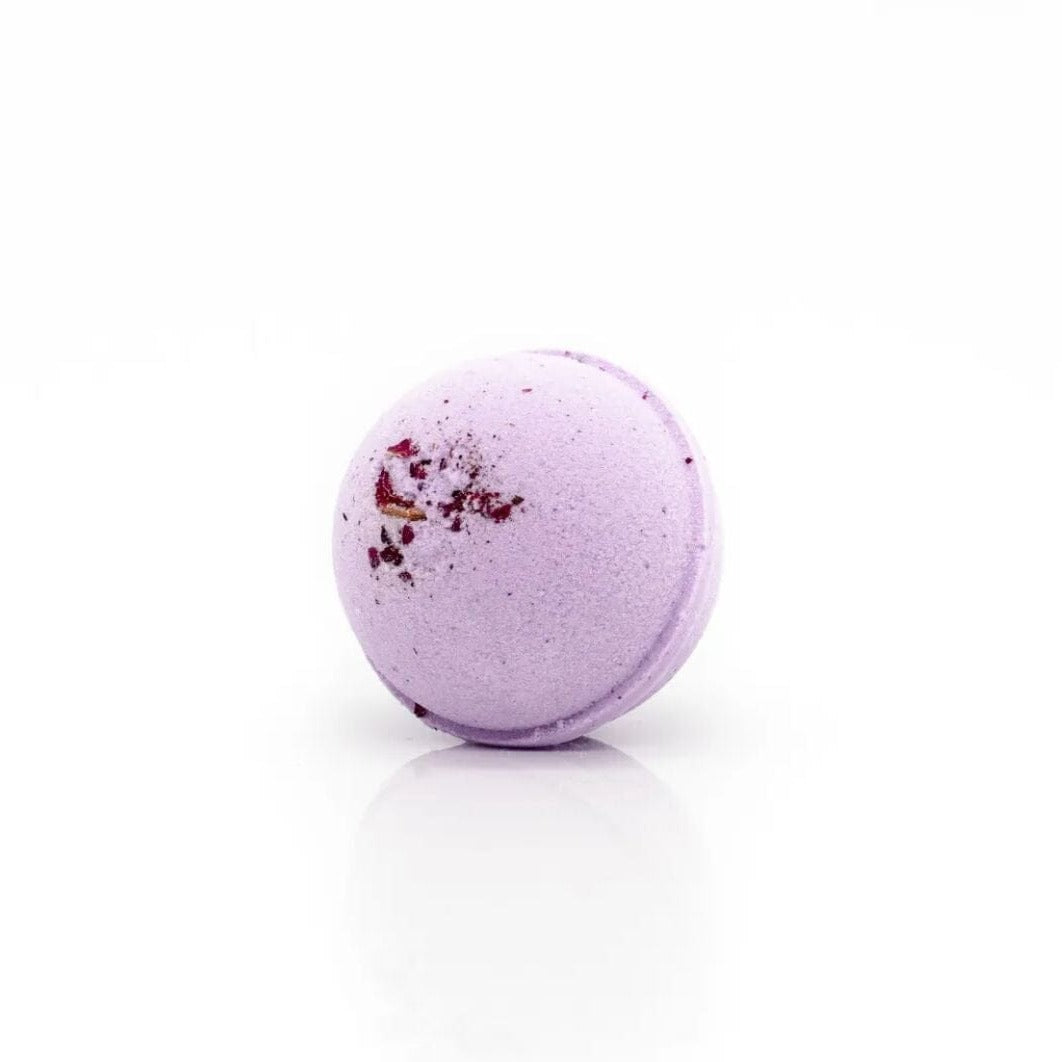 Lavendelfarbene CBD-Badebombe mit getrockneten Blütenblättern auf weißem Hintergrund, perfekt für ein entspannendes und aromatisches Bad.