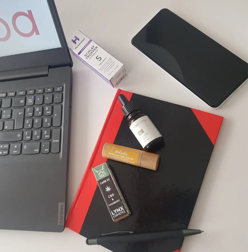 Arbeitsplatz von KANNOBA mit Laptop und ausgewählten CBD Produkten für Qualitätssicherung und Shop Pflege